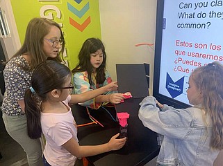 First-graders from Kaci Johnson's class, as well as STEAM and gifted and talented program instructor LaVon Francis, work on building a chair for Baby Bear to sit on, Tuesday, April 16, 2024, at Atlanta Primary School in Atlanta, Texas. The Mobile STEM Lab's Education Outreach Coordinator, Katie Askelson, said the large plush bear must be able to sit comfortably on top of the chair without the chair collapsing or the bear falling. All seven groups excelled at the task given during the lab time. (Staff photo by Mallory Wyatt)